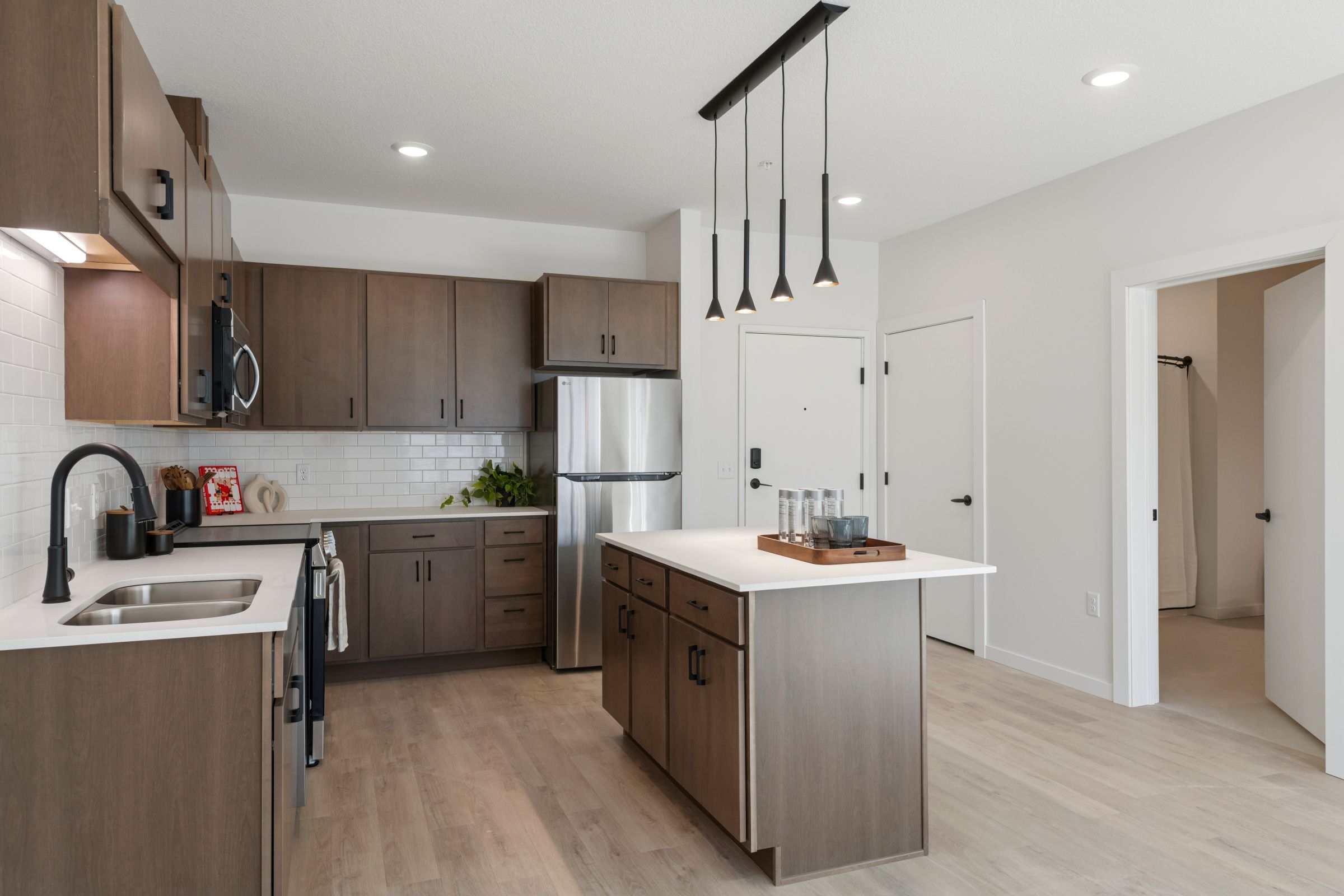 Modern kitchen with wood cabinets, stainless steel appliances, and a white countertop island.
