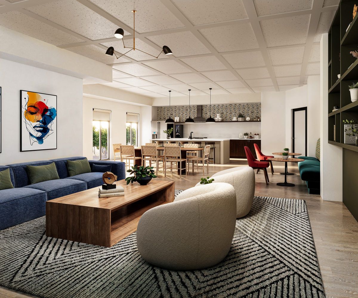 Modern open-plan community room and kitchen at Volta apartments, with cozy seating, large windows, and contemporary decor.