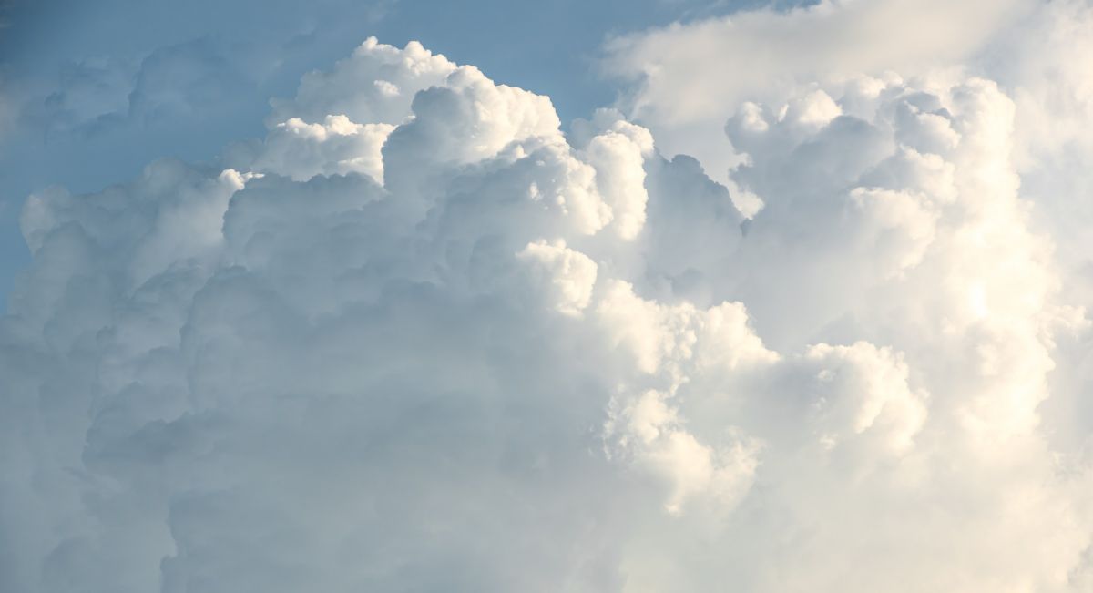 Large, fluffy white clouds against a blue sky on a bright, sunny day.